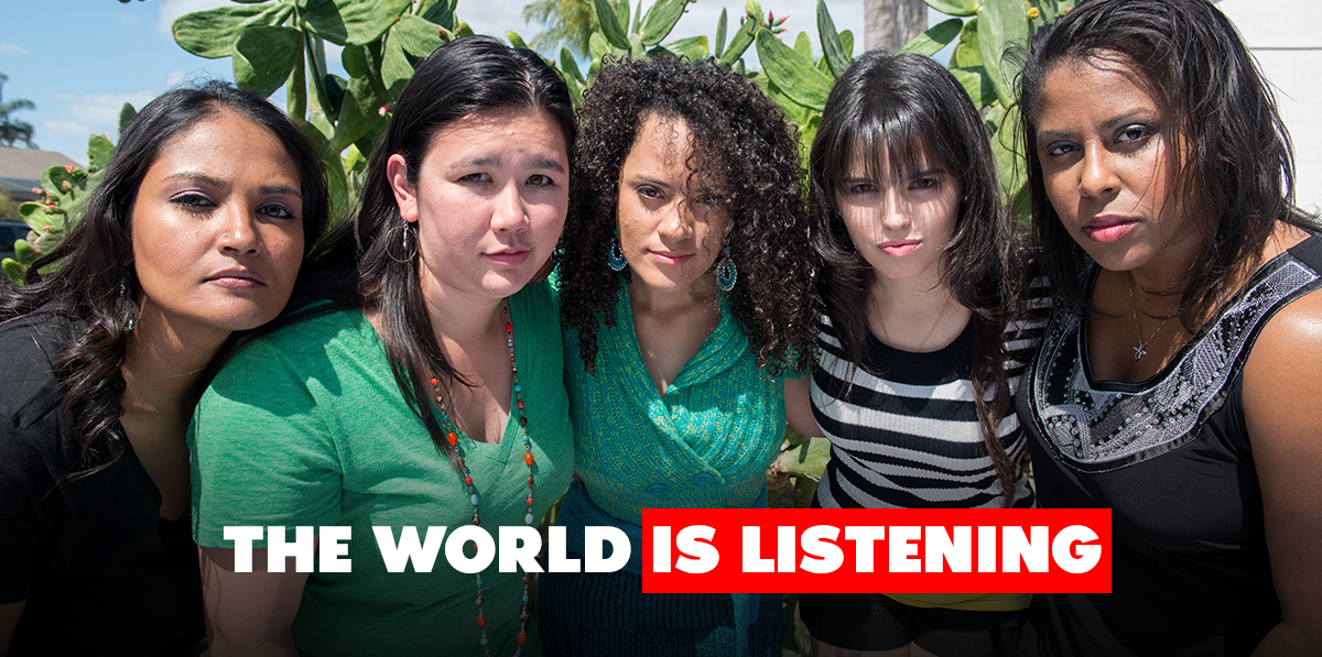 Petition-header-B Five women of diverse ethnicities link arms and lean forward to look into the camera. Text reads: The world is listening