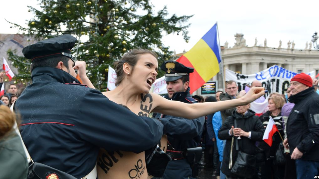 Police restrain a FEMEN activist outside The Vatican. Photo: AFP
