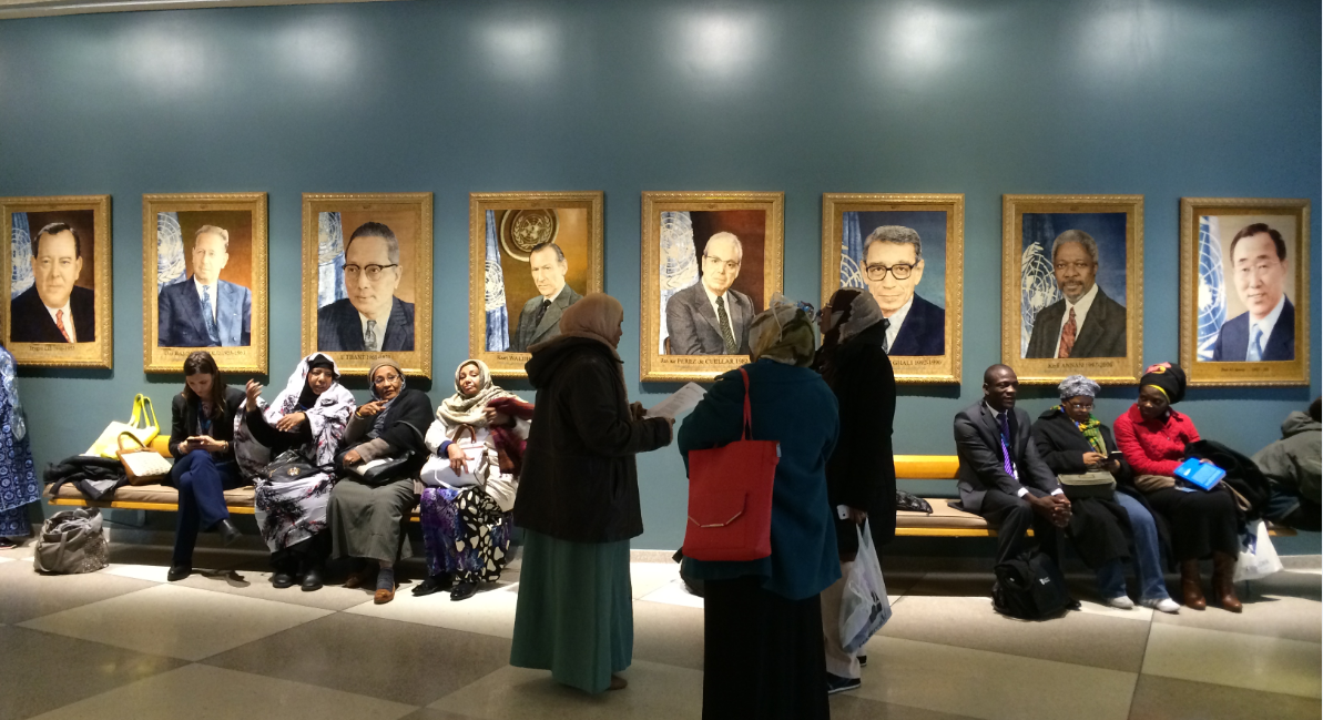 Women gather in front of portraits of the previous eight UN Secretary Generals at the 59th Commission on the Status of Women in 2015. Photo: Joanna Hayter